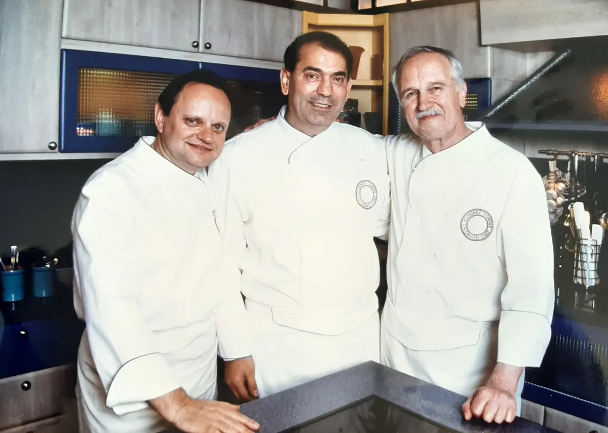 a mensch In chefs whites with 3 chefs