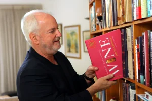 Adam Montefiore taking the Oxford Companion to Wine from a bookcase